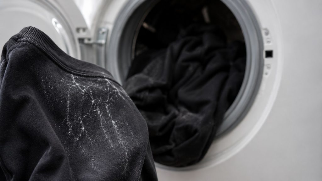 Białe plamy na czarnych ubraniach po praniu: detergent, przeładowany bęben czy twarda woda